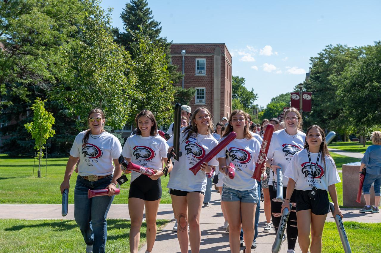 group of students walking down main sidewalk of campus during move in